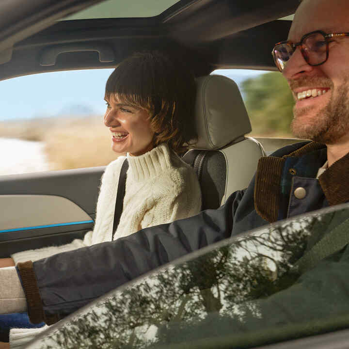 Couple souriant à l'intérieur de la voiture. 