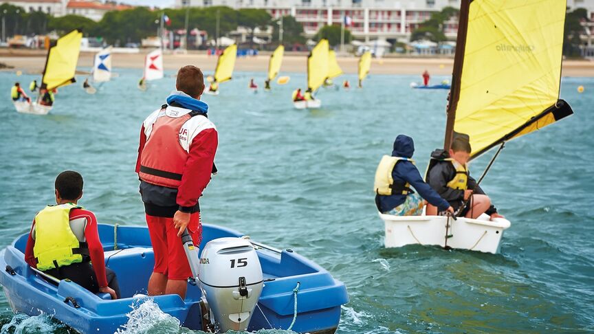 Homme sur un bateau, équipé d’un moteur BF15 en zone côtière. 