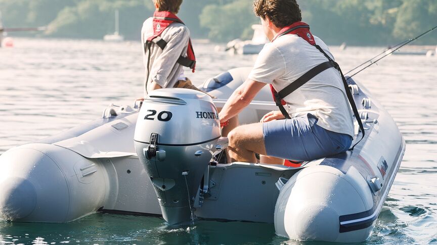 Homme sur un bateau, équipé d’un moteur BF15 en zone côtière. 