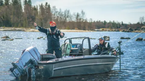 Deux messieurs sur un bateau de pêche avec un moteur Honda BF60 dans un endroit au bord d'un lac. 