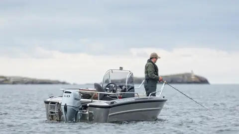 Gentleman pêchant sur un bateau avec moteur Honda BF60.