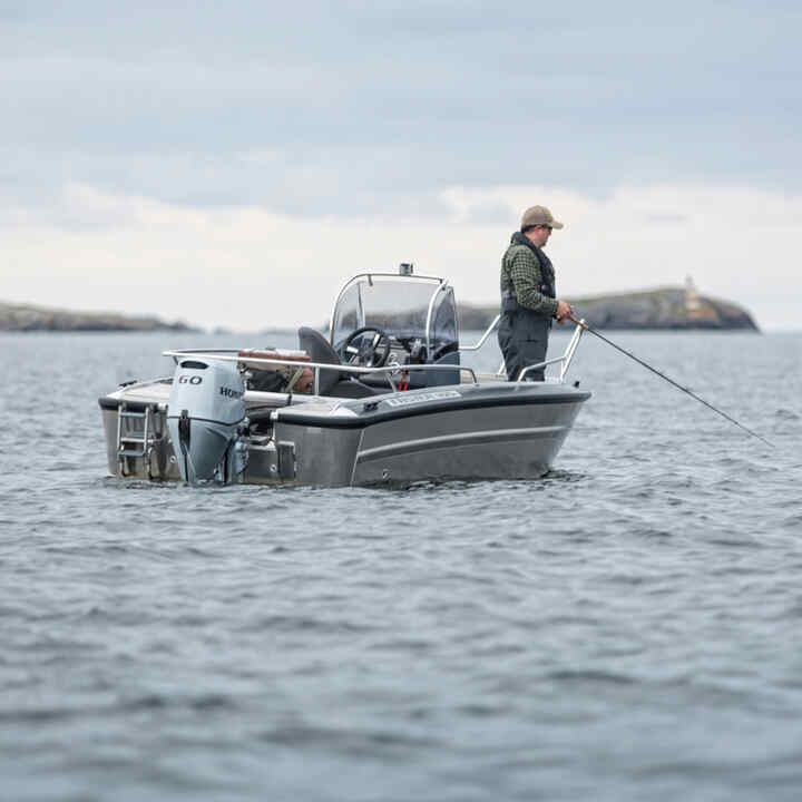 Homme sur un bateau équipé du moteur Honda BF60 dans l’océan. 