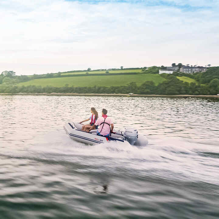 Couple sur un bateau Honwave au bord d’un lac utilisant un moteur Honda BF. 